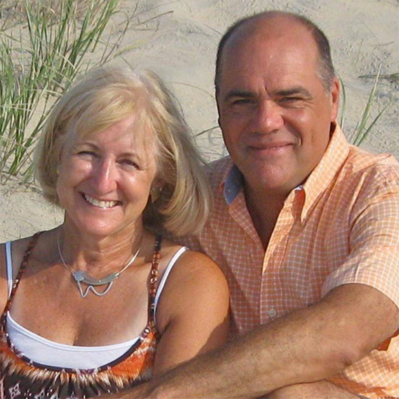 Man and woman UMCF supporters sitting on a beach.